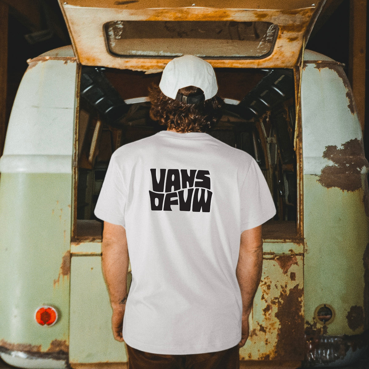 Man wearing white Old Volkswagens Ruined My Life t-shirt in front of a rusty VW Bus – vansofvw
